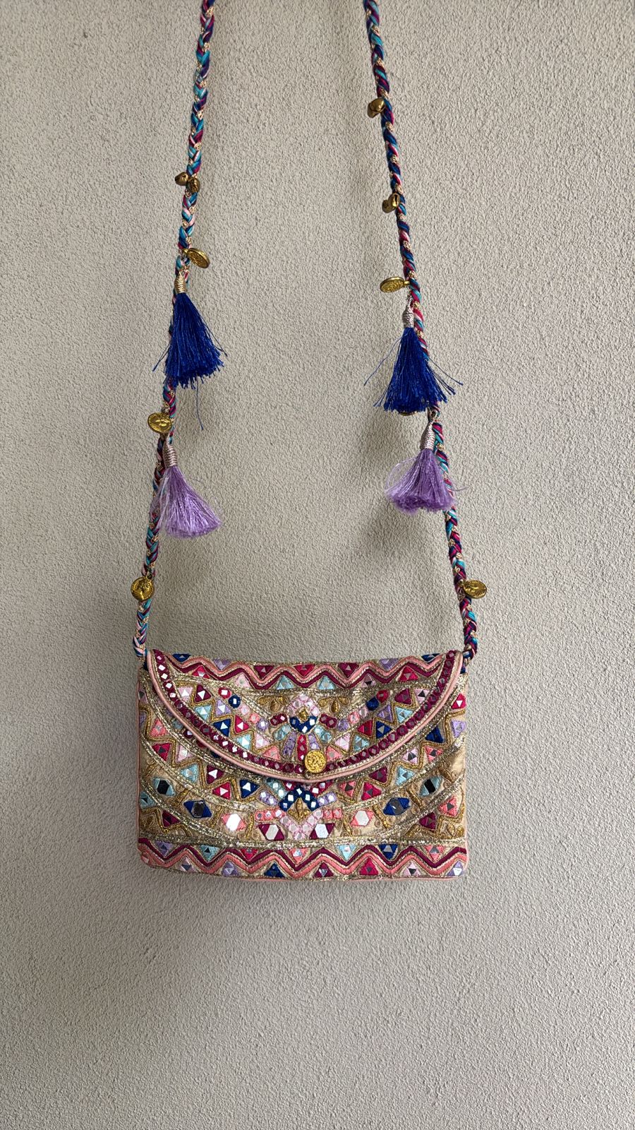 Ivory multicolored envelope bag with resham, gotta, dori, mirror work and tassel detailing on the sling