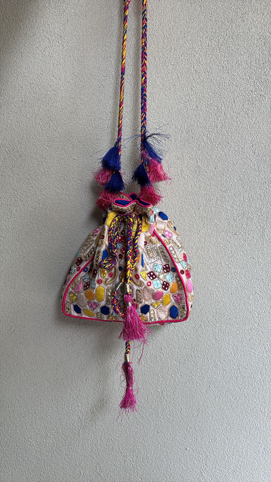 Ivory potli bag with resham, tassel and mirror detailing